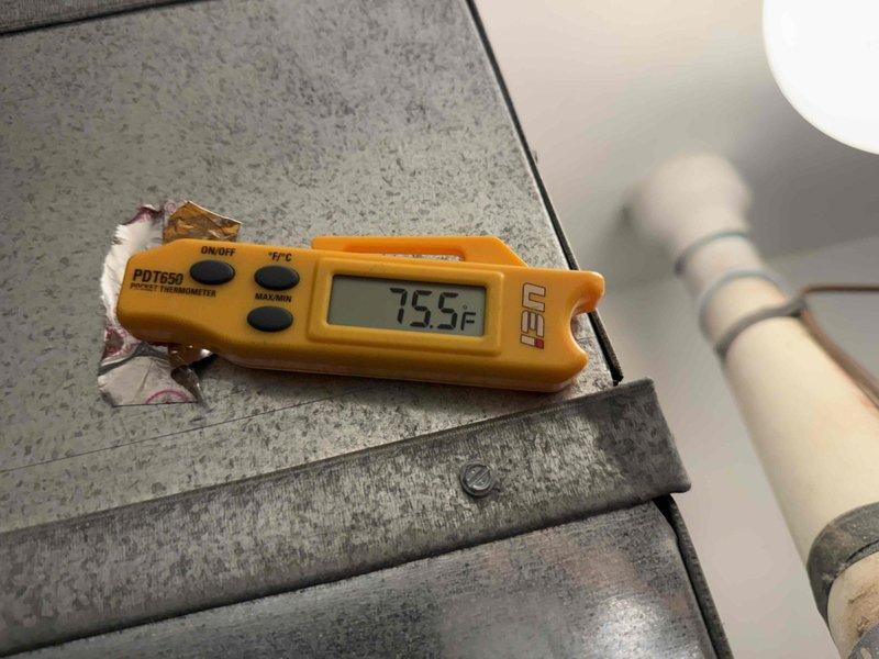 Responded to callback for blank thermostat and red indicator light on 2-year-old AC system following previous service visit. Upon arrival, inspected thermostat wiring and power supply, then proceeded to outdoor condensing unit where red light was reported. Evaluated system components and verified temperature readings at 75.5°F using digital thermometer at indoor unit. Inspected outdoor unit connections showing heat discoloration on suction line service valve and mounting hardware, indicating previous high-temperature operation. Checked refrigerant lines, electrical connections, and condensate drain system. Restored thermostat functionality and cleared fault condition, returning system to normal operation with proper temperature control.