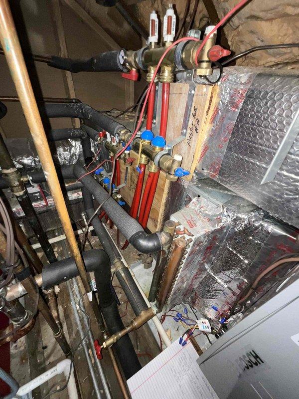 Assessed 15-year-old boiler system experiencing venting issues in confined mechanical space. Determined that the manufacturer is no longer in business, making parts sourcing extremely difficult and repairs unfeasible. Documented existing system configuration including complex piping assembly, ductwork, and confined installation environment in attic/crawl space area with stone foundation walls. Provided comprehensive estimate for tankless water heater replacement as alternative solution to address ongoing reliability concerns and parts availability challenges.