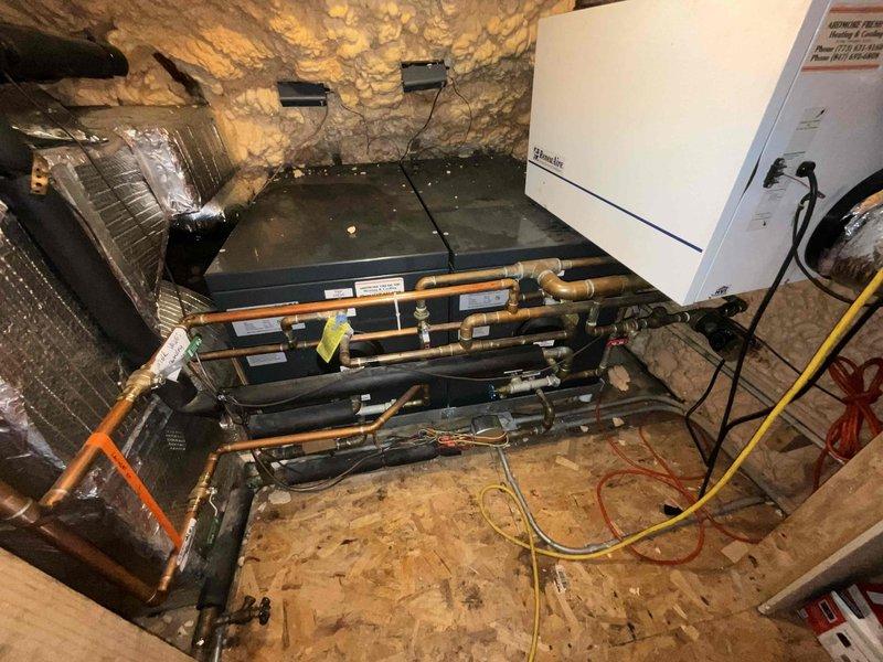 Assessed 15-year-old boiler system experiencing venting issues in confined mechanical space. Determined that the manufacturer is no longer in business, making parts sourcing extremely difficult and repairs unfeasible. Documented existing system configuration including complex piping assembly, ductwork, and confined installation environment in attic/crawl space area with stone foundation walls. Provided comprehensive estimate for tankless water heater replacement as alternative solution to address ongoing reliability concerns and parts availability challenges.