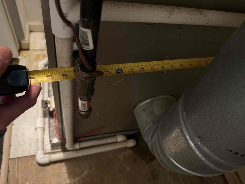 Performed comprehensive evaluation of 12-year-old HVAC system located in confined mechanical room for full system replacement estimate. Documented existing equipment configuration including air handler, ductwork, and associated plumbing components in cramped utility space. Assessed accessibility for replacement work, noting no ladder required for installation. Took measurements of available clearances and existing equipment footprint to determine proper sizing for new system. Provided detailed analysis comparing repair costs versus full system replacement options given age and condition of current equipment.