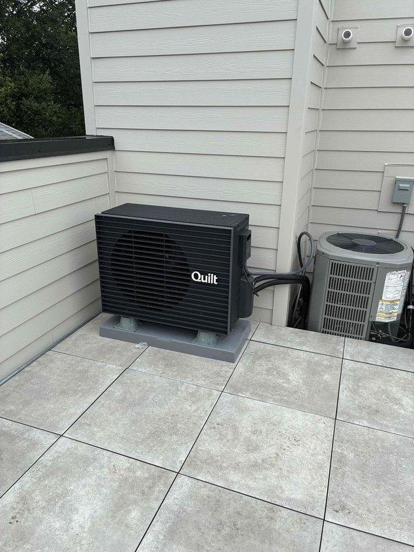 Completed full replacement of existing mini-split system with new Quilt brand ductless heat pump unit. Installed indoor wall-mounted evaporator unit in interior room near ceiling corner and positioned outdoor condenser unit on tiled patio area alongside existing HVAC equipment. Ran refrigerant lines between indoor and outdoor components, established proper electrical connections at exterior meter location, tested system operation, and verified cooling performance meets manufacturer specifications.