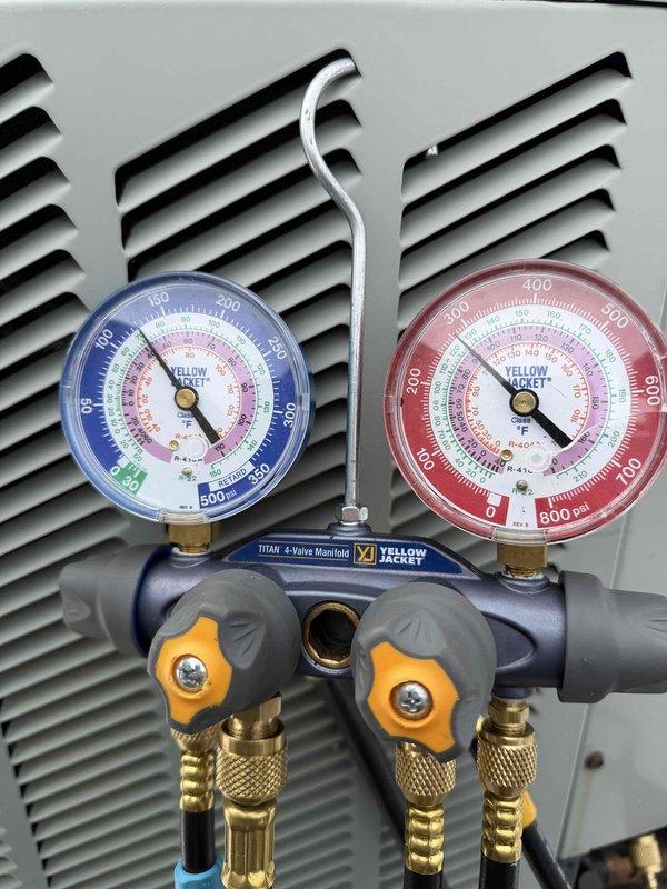 # HVAC Service Completed

Responded to no cooling call on system less than 10 years old. Upon arrival, found half inch of standing water accumulated under furnace unit in basement. Ecobee thermostat and system had shut down due to safety sensor activation, with sensor displaying both red and green indicator lights.

Investigated condensate drain system and identified blockage causing water backup. Cleared primary drain line obstruction and verified proper drainage flow. Tested condensate safety switch operation and confirmed proper functioning. Restored power to system and verified thermostat communication re-established.

Proceeded to rooftop to inspect two condenser units. Connected Yellow Jacket Titan 4-valve manifold gauges to measure refrigerant pressures and system performance. Evaluated refrigerant charge levels and operating pressures on both condensers. Checked compressor operation, fan motor function, and electrical connections at outdoor units.

Inspected 16x25x1 filter at f