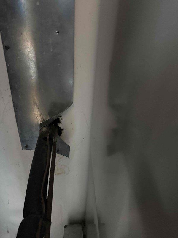 Responded to service call for visible leak from HVAC equipment dripping through ceiling. Upon inspection, identified water leakage originating from the air handler unit located in the attic space. Examined condensate drain system and evaporator coil assembly, noting accumulated dirt and grime on equipment components indicating maintenance neglect. Photographed affected areas showing water damage patterns on ceiling-mounted ductwork, support brackets, and surrounding surfaces. The leak appears to be related to condensate drainage issues, with visible moisture accumulation around the drain pan area and connecting components. Documented condition of galvanized ductwork, mounting hardware, and associated piping for further assessment and repair recommendations.