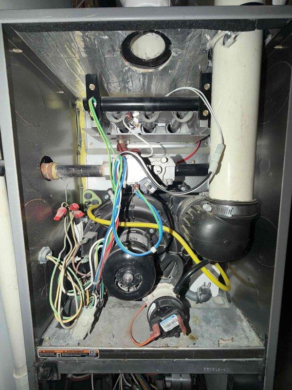 Completed comprehensive HVAC maintenance agreement inspection on combination heating and cooling system. Performed temperature diagnostics on supply ductwork, recording 53.3°F reading at metallic supply plenum. Conducted thorough internal inspection of gas furnace unit, documenting electrical connections, blower assembly components, PVC condensate drain system, and verifying proper wiring configuration throughout all system components.