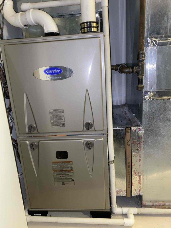 Successfully completed full furnace and humidifier replacement at residential property. Removed existing heating equipment and installed new Carrier brand high-efficiency furnace unit with proper venting configuration using white PVC piping. Connected all ductwork components including metallic supply plenum to ensure proper air distribution throughout the home. Installed new humidifier system with appropriate water supply lines and brass fittings. Verified thermostat communication with new unit showing proper temperature reading of 75 degrees on digital display. Completed all electrical connections, tested system operation, and confirmed equipment is functioning within manufacturer specifications.