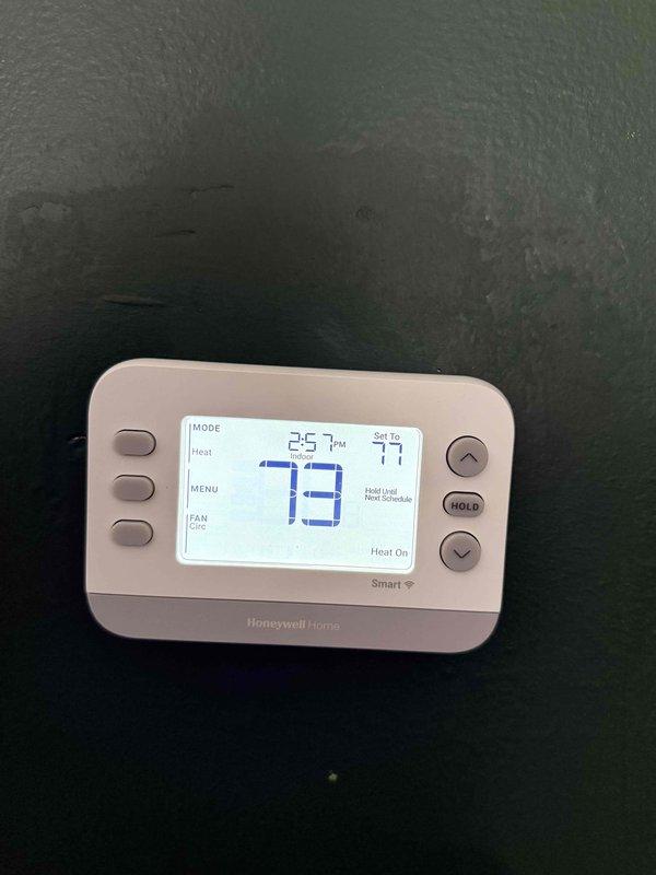 Completed preventive maintenance inspection on residential furnace system under maintenance agreement. Verified thermostat operation showing proper heating mode engagement with system actively running, inspected blower wheel assembly and housing for operational condition, and documented equipment status with photographic records for service files.