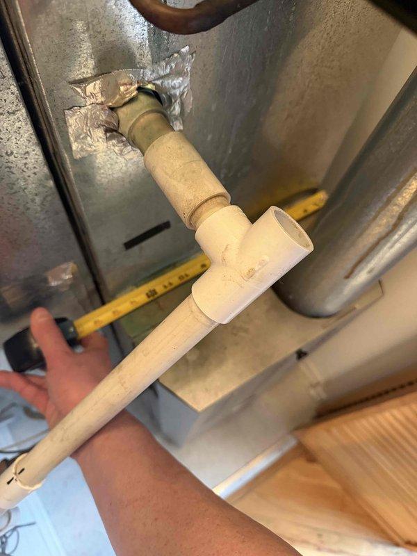 Conducted comprehensive on-site evaluation of existing HVAC system in utility mechanical space to provide full system replacement estimate for furnace and air conditioning unit. Documented current equipment condition, including deteriorated ductwork connections with damaged foil tape and aging PVC condensate drain piping, and assessed installation access requirements through industrial fire escape platform area with concrete utility room access point.