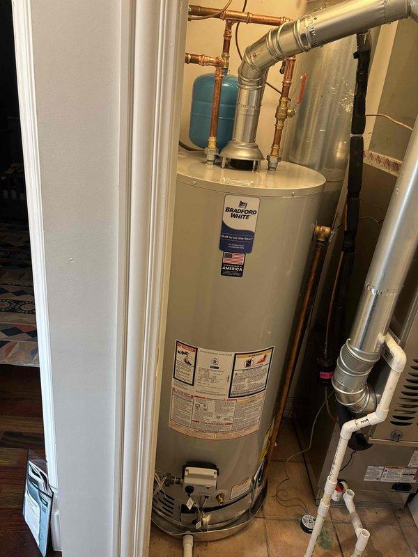 Installed a 50-gallon Bradford White tanked water heater with all necessary plumbing connections, including brass ball valves and copper piping with press-fit fittings. Added an expansion tank to the system and installed a new emergency drain pan beneath the unit for overflow protection. All connections were pressure-tested and verified operational upon completion.