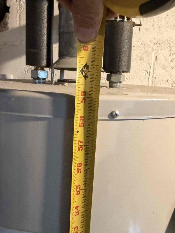 Responded to service call for non-operational water heater following recent service visit. Upon arrival, performed comprehensive inspection of GE residential electric water heater unit installed in basement utility area. Verified all plumbing connections, pressure relief valve operation, and electrical supply to unit. Conducted diagnostic measurements of equipment clearances and mounting components to ensure proper installation specifications were met. Documented existing conditions with photographic evidence showing water heater positioning, pipe connections, and associated mechanical infrastructure for service records.