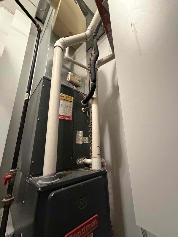 Conducted comprehensive estimate visit for dual-zone HVAC system replacement in large residential property. Evaluated existing 20-year-old Trane/Goodman equipment including basement-installed furnace and air conditioner, plus main floor furnace and heat pump, all original to the home and approaching end of service life. Basement system replacement specified as like-for-like gas furnace and air conditioning unit; main floor system designed as hybrid configuration with heat pump primary heating and downsized gas furnace backup for enhanced efficiency. Reviewed installation requirements for both utility closet and main floor closet locations, assessed existing ductwork, electrical service, venting arrangements, and condensate drainage systems. Documented current equipment specifications, photographed existing Goodman furnace installation with PVC venting and electrical connections, and captured smart thermostat configuration. Presented equipment options from Trane and Carrier product line