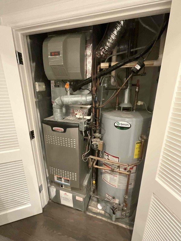 Conducted comprehensive assessment of existing residential HVAC system and water heating equipment for full system replacement estimate. Evaluated current installation consisting of gas furnace, AO Smith water heater, and integrated humidifier unit housed in utility closet, documenting equipment conditions, existing ductwork configuration including metallic flex duct and ventilation routing, plumbing connections with copper and PVC piping, electrical service, and spatial constraints for replacement equipment sizing and installation access.