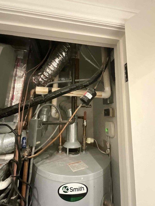 Conducted comprehensive assessment of existing residential HVAC system and water heating equipment for full system replacement estimate. Evaluated current installation consisting of gas furnace, AO Smith water heater, and integrated humidifier unit housed in utility closet, documenting equipment conditions, existing ductwork configuration including metallic flex duct and ventilation routing, plumbing connections with copper and PVC piping, electrical service, and spatial constraints for replacement equipment sizing and installation access.