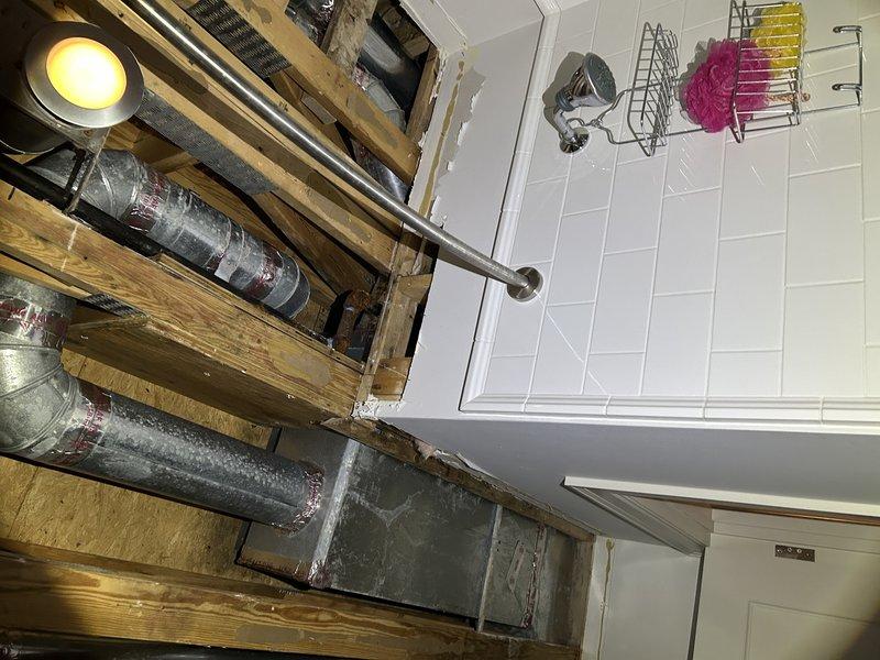Responded to ongoing condensation issue causing drywall damage in bathroom ceiling area. Accessed attic space above bathroom and wrapped previously exposed ductwork with bubble wrap insulation to prevent further condensation buildup. Installed insulation on multiple sections of metallic ductwork running through ceiling joists, securing material with appropriate fasteners and support brackets. Verified all accessible ductwork in affected area is now properly insulated to maintain temperature differential and eliminate moisture accumulation on duct surfaces.