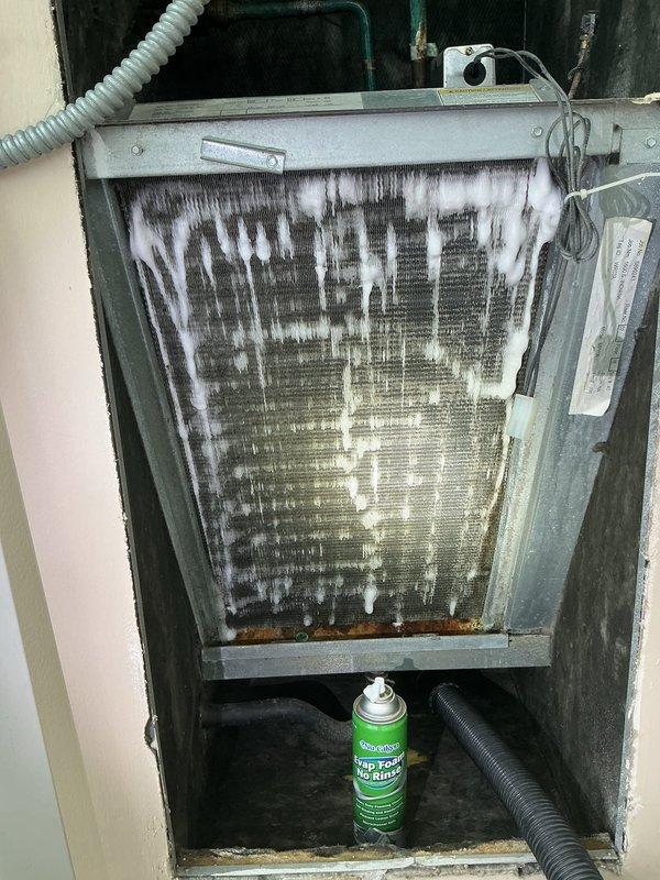 Returned to property to complete evaporator coil cleaning as part of building wellness check follow-up. Upon arrival, found extensive ice and frost buildup covering the entire evaporator coil assembly, with heavy accumulation on fins and icicle-like formations indicating active freezing condition. Addressed the frozen coil issue, performed thorough cleaning of the evaporator coil to remove dirt, dust, and debris accumulation from fin surfaces. Cleaned corroded areas at base of unit and ensured proper system operation upon completion.