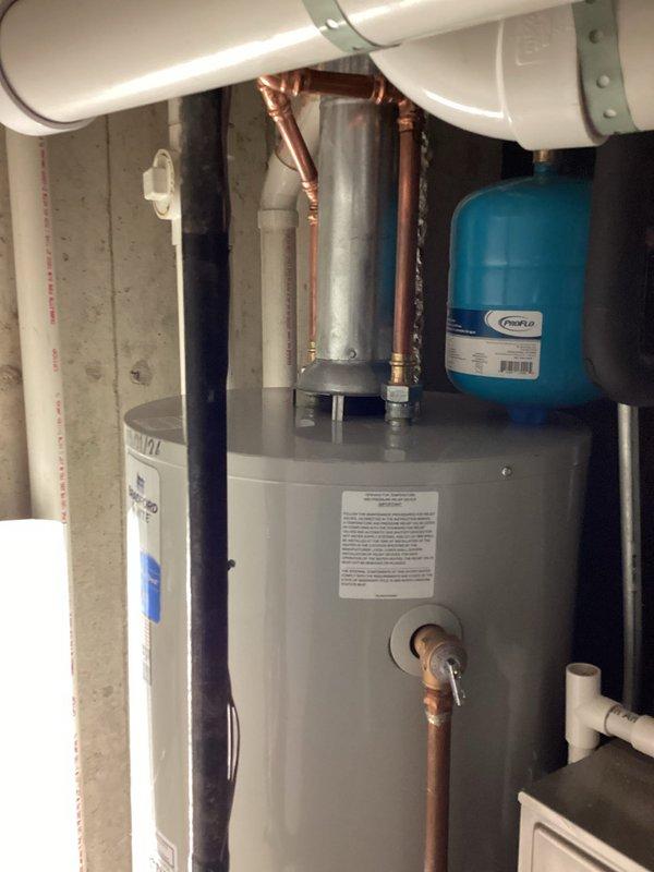 Completed installation of a 50-gallon Bradford White tanked water heater in residential utility space. Installed new expansion tank to protect the system from thermal expansion pressure damage and ensure code compliance. All copper supply lines were properly connected, PVC venting system was routed and secured, and pressure relief valve discharge piping was installed per manufacturer specifications. System was tested for proper operation, checked for leaks, and verified all connections meet current plumbing standards.