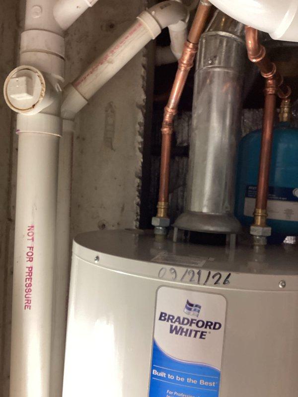Completed installation of a 50-gallon Bradford White tanked water heater in residential utility space. Installed new expansion tank to protect the system from thermal expansion pressure damage and ensure code compliance. All copper supply lines were properly connected, PVC venting system was routed and secured, and pressure relief valve discharge piping was installed per manufacturer specifications. System was tested for proper operation, checked for leaks, and verified all connections meet current plumbing standards.
