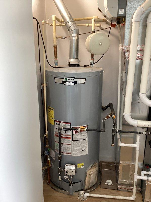 Completed comprehensive whole-home plumbing inspection with specific focus on third-floor bathroom sink experiencing foul odor from drain and reduced water pressure. Inspected dual-sink vanity installation, verified proper trap configuration, and assessed all visible supply lines and drainage connections. Examined water heater system including A.O. Smith tank unit, expansion tank, supply piping, and associated gas connections to ensure proper operation and rule out pressure-related issues affecting upper-level fixtures.