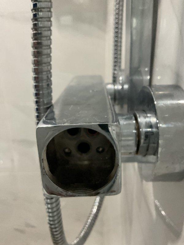 Completed shower cartridge replacement on chrome thermostatic mixing valve in modern tiled shower enclosure. Removed existing cartridge from wall-mounted control valve, installed new replacement cartridge, tested water temperature control and flow distribution between rain head and handheld shower attachment to verify proper operation of diverter system.