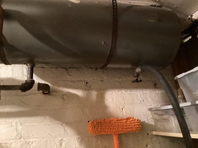 Completed scheduled maintenance agreement inspection on residential gas boiler system. Documented interior burner assembly showing moderate dust and debris accumulation on burner tubes, chamber surfaces, and surrounding components, with all structural elements remaining intact and functional. Inspected horizontally-mounted expansion tank installation and associated piping connections in utility area, verifying proper mounting and system configuration.