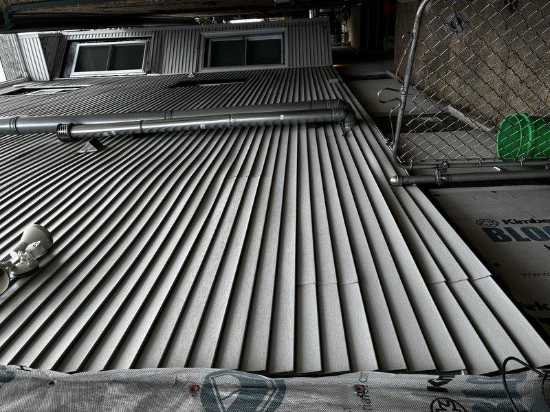 Conducted comprehensive evaluation of existing boiler system exceeding 10 years of service life. Unit currently operational but has demonstrated declining reliability over multiple heating seasons, prompting replacement assessment. Documented existing equipment configuration including basement installation with associated piping infrastructure and exterior venting components terminating through corrugated metal roof structure.