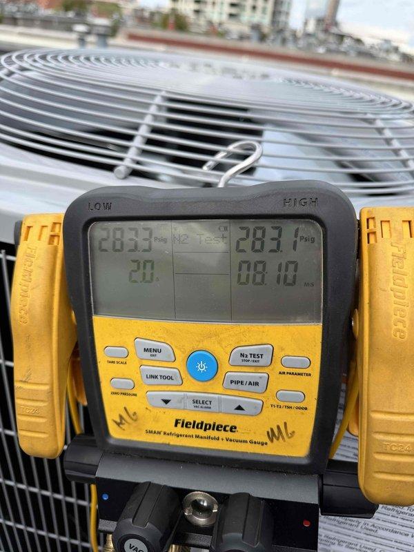 Completed install warranty inspection on rooftop condenser unit. Verified proper operation of newly installed system, confirmed refrigerant pressures reading 283 PSI on high side with appropriate temperature differential of 20 degrees. Inspected copper line set connections with insulation sleeves, service valves, and electrical conduit for proper installation standards. Unit operating within manufacturer specifications with all AHRI and UL certifications visible and intact.