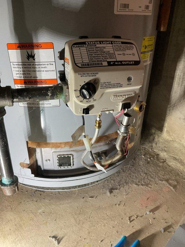 Responded to no hot water complaint on residential water heater. Upon inspection, found failed inducer motor assembly preventing unit operation. Removed defective blower motor from combustion chamber, which showed signs of dust accumulation and mechanical wear. Replaced inducer motor assembly and verified proper operation of gas control valve and venting system. Tested unit for proper ignition sequence and confirmed hot water restoration.