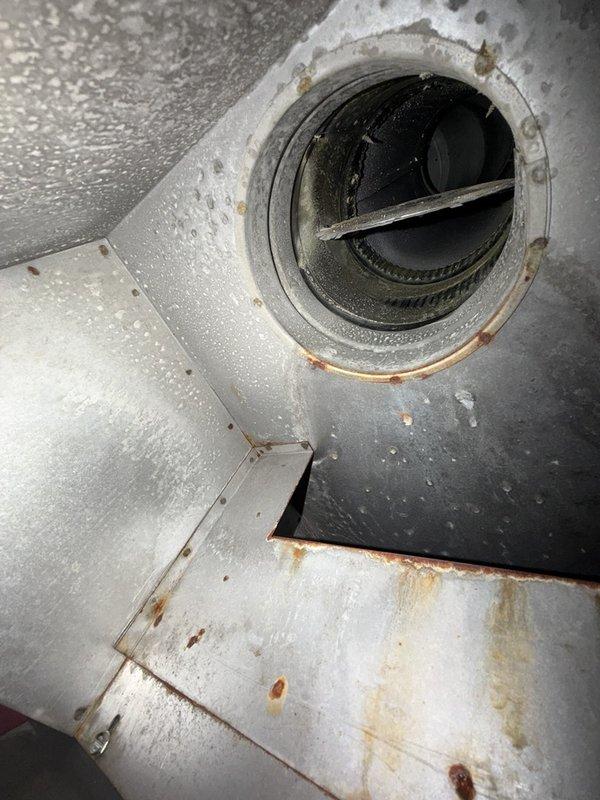 Completed comprehensive maintenance inspection on CC 1 boiler system under agreement terms. Documented system condition through photographs, revealing significant rust accumulation on ventilation ductwork connections, condensation throughout duct assembly indicating potential temperature differential issues, and visible corrosion on heating element terminals and connectors. Inspected internal heating components including terminal strips with brass connectors showing oxidation and dust buildup, examined insulation condition noting deterioration and contamination, and assessed overall system integrity for continued safe operation.