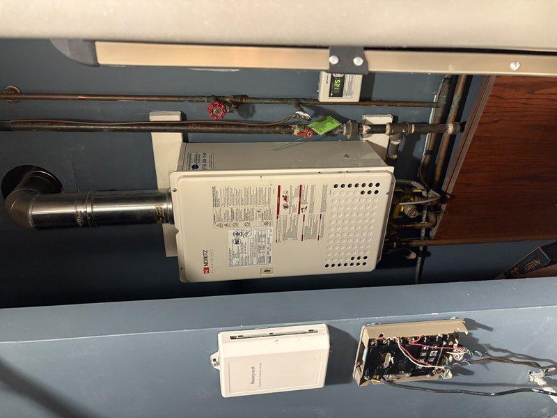 Performed comprehensive assessment of existing 20-year-old Noritz tankless water heater installation in mechanical room. Documented current equipment configuration including exhaust venting system, copper supply piping with shutoff valves, electrical connections, and mounting arrangement. Provided estimate for complete tankless water heater replacement to address age-related concerns and ensure continued reliable operation.