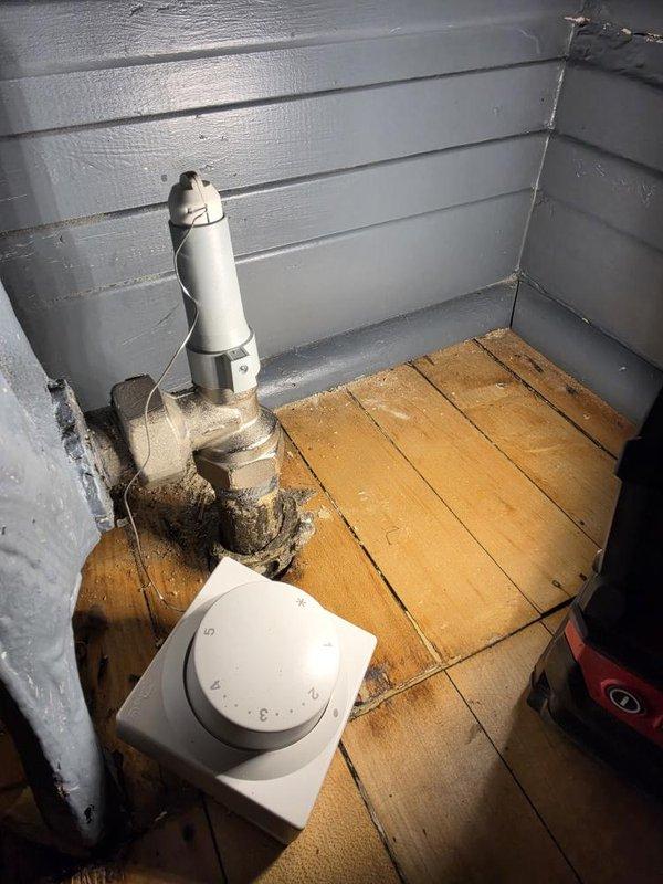 Returned to site with correct replacement valve and successfully replaced faulty radiator valve on exterior hydronic heating system. The new brass valve with black handle was installed on wooden deck area against exterior wall, completing the heating system repair. Payment was collected upon completion of the work.