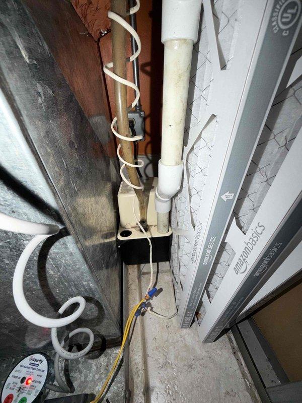 Responded to callback for wet switch showing red light indicator with moisture accumulation at base of unit. Upon arrival, inspected air handler and condensate management system, noting significant dust and debris buildup on equipment exterior. Documented existing conditions with photos showing wet switch status, PVC condensate drain line configuration, and overall system installation. Verified wet switch was recently installed and confirmed moisture presence at bottom of unit. Issue determined to be related to original concern and addressed under warranty provisions as no-charge callback.