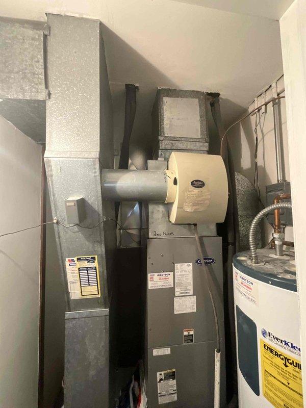 Performed on-site evaluation of 25-30 year old residential heating and air conditioning system for complete replacement estimate. Inspected existing furnace, air conditioning unit, ductwork configuration, and related mechanical components in utility space. Documented current system specifications, equipment age, installation layout, and existing infrastructure including refrigerant lines, electrical connections, and ventilation components. Assessed mechanical room dimensions and equipment accessibility to determine replacement requirements and compatibility. Photographed existing furnace with manufacturer labels, integrated air purification system, ductwork routing, refrigerant line insulation, and copper piping connections for estimate preparation. No immediate system failures or urgent operational issues identified during inspection. Provided comprehensive replacement options and recommendations based on current equipment condition and residential heating and cooling requirements.