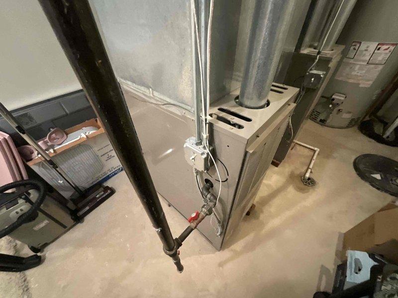 Conducted on-site evaluation of existing HVAC system for replacement estimate. Inspected 16-year-old furnace unit located in mechanical room, assessed condition of ductwork including galvanized metal supply runs and ventilation components, and evaluated overall system layout and equipment accessibility. Reviewed current thermostat and control system mounted in living space to determine compatibility requirements for new equipment installation.