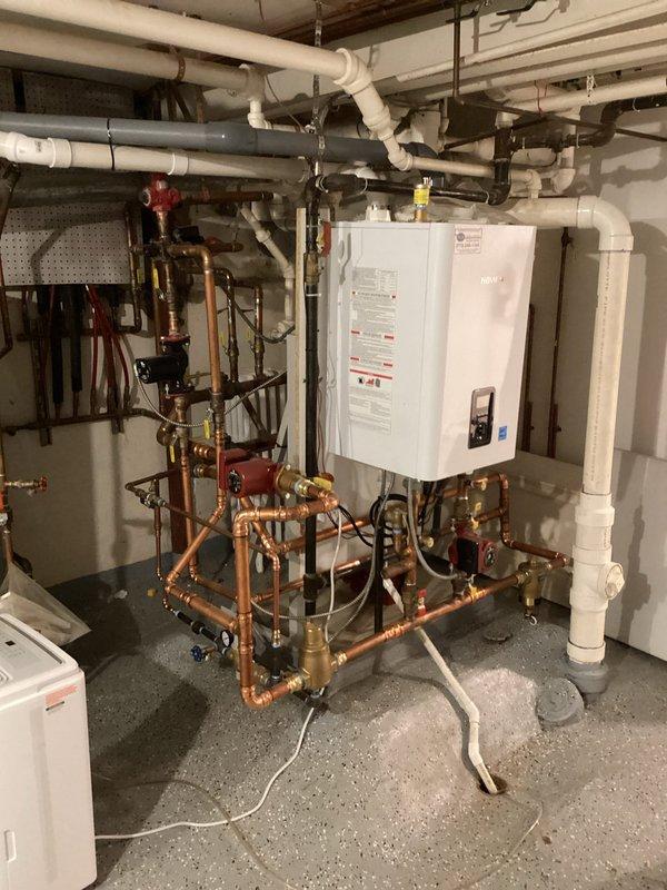 Performed comprehensive maintenance on wall-mounted combination tankless boiler and water heater system. Removed front access panel and inspected all internal components including blower assembly, heat exchanger, gas valve, circuit boards, and digital control interface. Verified proper operation of manifold system with pressure gauges, expansion tanks, and isolation valves. All mechanical and electrical components found in satisfactory working condition with no issues identified.
