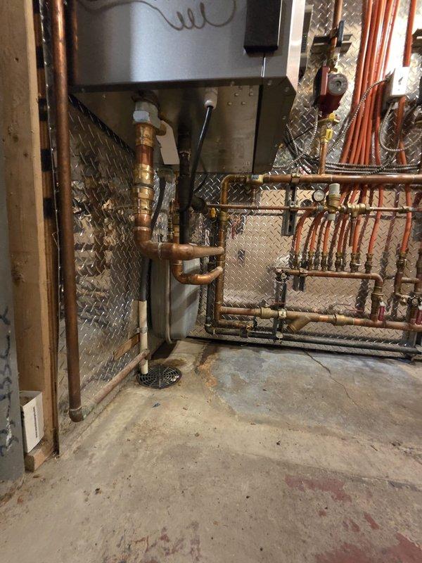 Completed full boiler replacement in residential basement, removing existing unit and installing new warrantied boiler system. Coordinated equipment exchange, returning old boiler and picking up replacement unit on-site. Connected new boiler to existing hydronic distribution manifold with copper piping and verified all connections to radiant heating system. Performed thermal imaging scan of living space to confirm proper heat distribution and system operation, with temperature readings showing consistent performance throughout service area ranging from 61.7°F to 67.6°F.