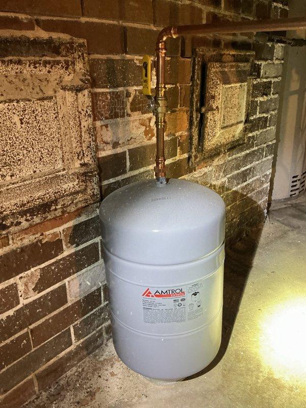 Completed annual maintenance inspection on boiler system under service agreement. Documented existing conditions including expansion tank, piping connections, and system components with photographic evidence. Observed significant moisture infiltration and efflorescence on basement brick wall adjacent to equipment, indicating ongoing water seepage issues that may require future attention to prevent equipment corrosion and structural deterioration.