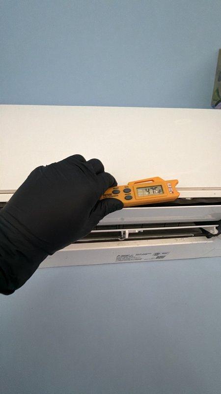 Responded to a water leak complaint on a 15-year-old Unico mini-split system. Inspected the indoor unit and verified supply air temperature of approximately 47.5°F at the outlet to confirm proper cooling operation. Connected a reinforced hose to the unit's drain line to flush and clear the condensate drain obstruction, restoring proper drainage and resolving the leak.