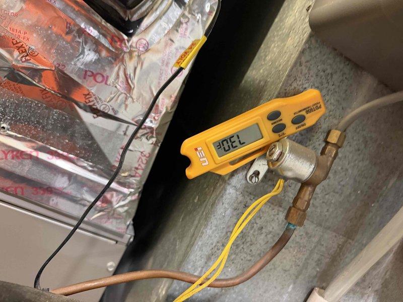 Responded to a no-cool call where the indoor blower operated but the outdoor condensing unit failed to energize following a recent blower motor and wheel replacement. Inspected the air handler control board and low-voltage wiring, which was found dense and disorganized with loosely draped and tangled conductors, and verified the thermostat control circuit and 24V signal path to the condenser contactor. Checked the refrigerant-side components, including the valve and brass fitting connections, and measured line temperature to confirm system operation and restore cooling.
