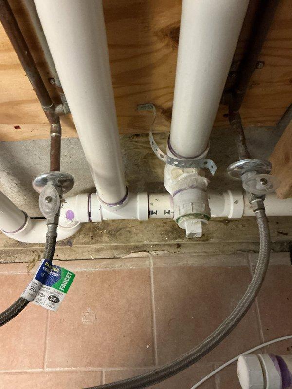 Inspected the laundry area drain and supply plumbing to locate the reported leak and identified staining at the base of the PVC drain assembly where it meets the floor drain. Repaired the PVC drain connections, including primed and cemented joints and fittings, and verified the braided stainless steel supply lines and shutoff valves were secure and leak-free. Tested the system under normal operation to confirm the leak was resolved.