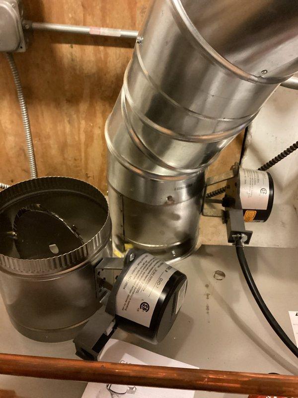 Returned to replace a defective flue damper actuator motor on the recently installed boiler under manufacturer warranty. Removed the failed motor from its mounting bracket, installed the new warranty motor, and reconnected the wiring, then verified secure mounting and proper damper blade operation with no visible damage to the flue or connected components.