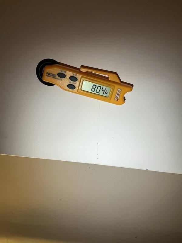 Performed annual maintenance on a natural gas upright furnace, including visual inspection of the cabinet, plenum, flue venting, and gas piping, with no frost, ice, or significant corrosion observed. Verified system operation and checked supply air temperature with a digital pocket thermometer, which measured approximately 80°F. Noted accumulated dust and debris around the furnace base.