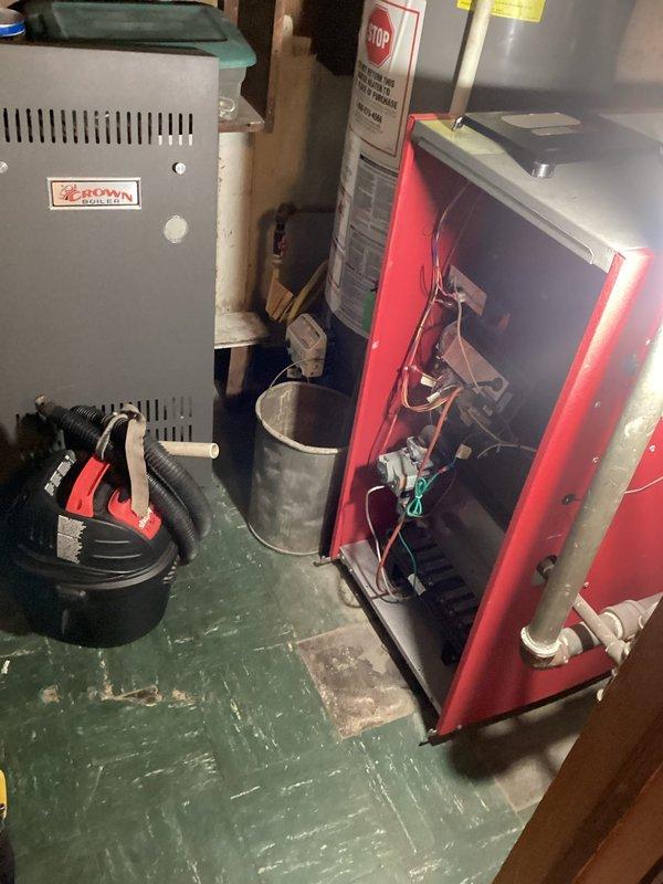 Performed scheduled maintenance on a Crown boiler system under the service agreement, inspecting the burner assembly, gas valve components, and internal control wiring with the front panel removed. Reviewed the exposed, loosely routed low-voltage wiring at the junction box and terminal connection on the piping and recommended securing and tidying the conductors; the work area was left clear of tools and equipment.