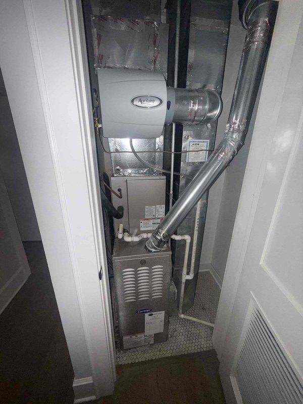 Performed seasonal maintenance on two Carrier gas furnaces, including inspection of the gas valve, flame sensor, wiring harnesses, and control board, and replaced the 16x20x1 air filters. Serviced the Aprilaire whole-house humidifiers, installing new #35 water panels. Noted corrosion and residue buildup on the wire sleeving near the burner compartment, and the system was otherwise found free of frost, rust, or visible damage.