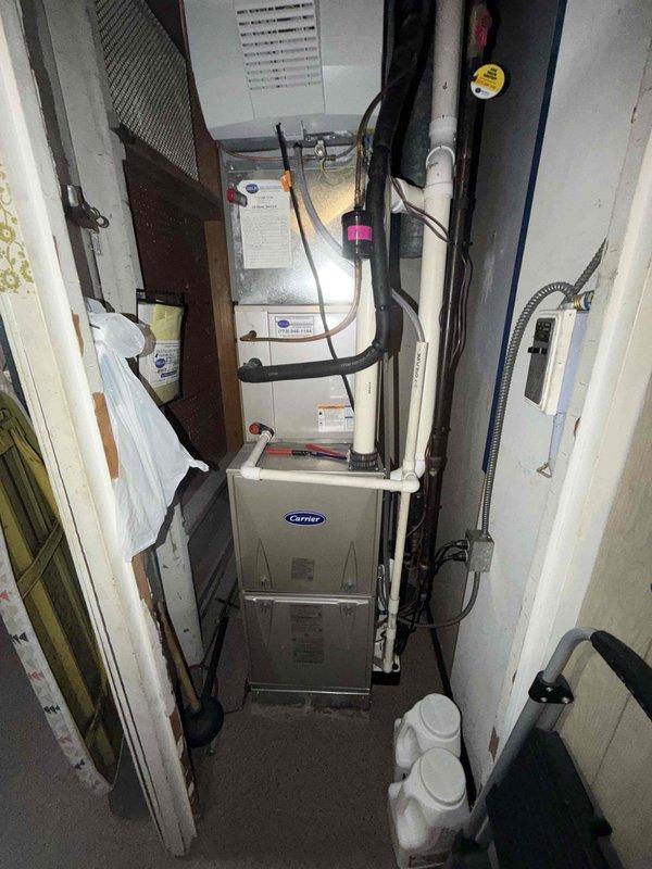 Responded to a no-heat call on a Carrier gas furnace with a coil cabinet in a closet installation. Inspected the unit and verified supply-air temperatures at the duct with a digital thermometer, and checked the condensate PVC drain, electrical connections, and refrigerant line set for proper condition. Restored heating operation and confirmed the furnace is operating normally.