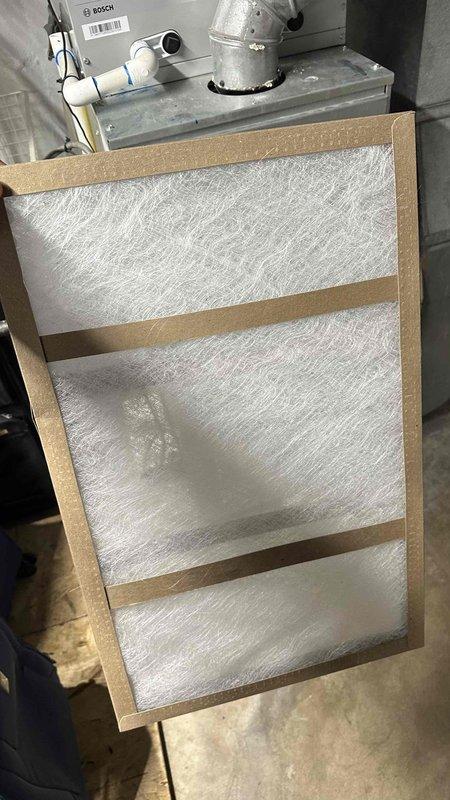 Performed scheduled maintenance on a Bosch gas furnace, including inspection of the unit, flue venting, and condensate piping. Removed the heavily soiled, dust-laden air filter and installed a new fiberglass disposable filter to restore proper airflow and protect the blower and heat exchanger components.