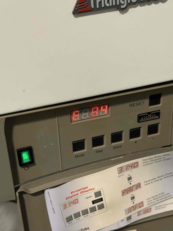 Responded to a no-heat call where the thermostat displayed only a cooling option. Diagnosed with a clamp meter and found the air handler's control board partially detached from the cabinet with several low-voltage wires (R, W, G, Y, C) disconnected and loosely twisted together, interrupting the heat call. The Triangle Tube Prestige boiler was also displaying an E.04 fault code. Inspected the control board, wiring, and boiler display, and documented the findings; recommended repair of the control board and low-voltage wiring and further evaluation of the thermostat and boiler fault.