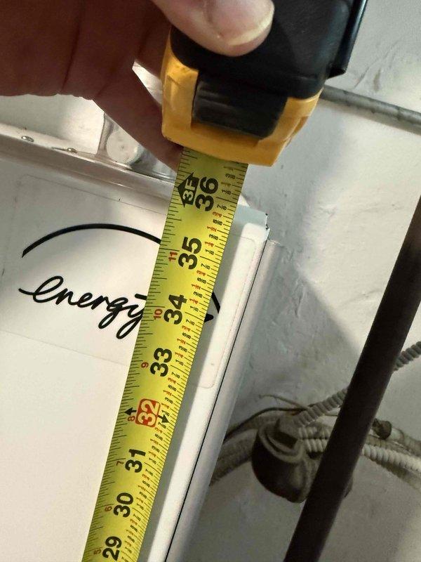 Performed an on-site evaluation and prepared a replacement quote for a Triangle Tube boiler. Inspection revealed a cracked blue rubber hose connection with a corroded copper fitting, mineral buildup, and rust staining at the boiler's flanged fitting, and clearance measurements were taken at the existing unit location to confirm sizing and installation requirements for the new boiler.