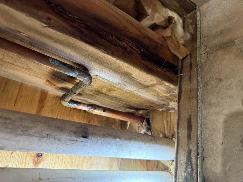 Replaced seven faucet/valve cartridges, installed a battery backup sump pump, and fitted an ejector pit cover to seal the basin. Removed and replaced a ruptured, corroded copper supply line with a brass compression connector, and noted verdigris corrosion at an elbow on the overhead copper run for future monitoring.