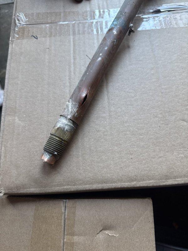 Replaced seven faucet/valve cartridges, installed a battery backup sump pump, and fitted an ejector pit cover to seal the basin. Removed and replaced a ruptured, corroded copper supply line with a brass compression connector, and noted verdigris corrosion at an elbow on the overhead copper run for future monitoring.