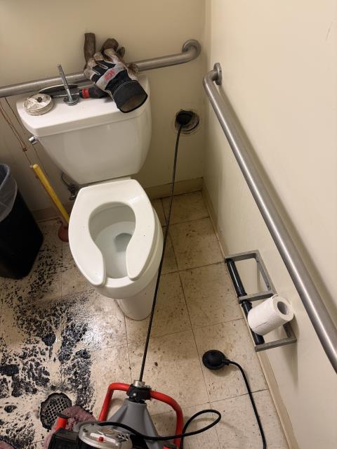 Upon arrival, both bathrooms were inspected and found to have completely backed-up toilets and floor drains, indicating a main sewer line blockage. After locating and accessing the cleanouts, our service technician deployed a drain snake and worked it thoroughly through both access points in an effort to reach and clear the obstruction while also addressing any additional buildup within the system.

The clog was successfully cleared from the men’s bathroom cleanout, restoring proper flow throughout the line. To confirm functionality, both toilets were flushed multiple times, and water was run continuously to ensure full drainage and performance of the system. Once proper operation was verified, both bathrooms were thoroughly cleaned and sanitized, removing all traces of sewage and leaving the area in proper working and sanitary condition.