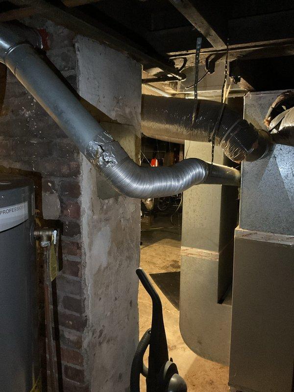 Completed comprehensive inspection of existing furnace system in basement utility area, documenting current installation configuration including main unit, air handler, ventilation components, and ductwork connections. Assessment revealed aging equipment with flexible metallic S-shaped ductwork that requires replacement. Prepared estimate for complete furnace system replacement with modern, energy-efficient alternative.